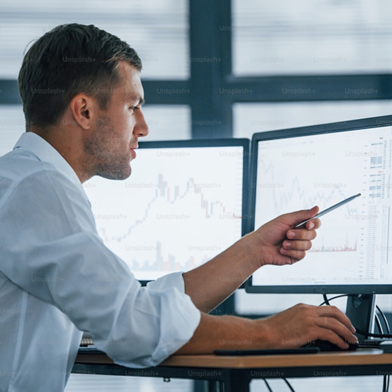 Man points at screen showing investment data